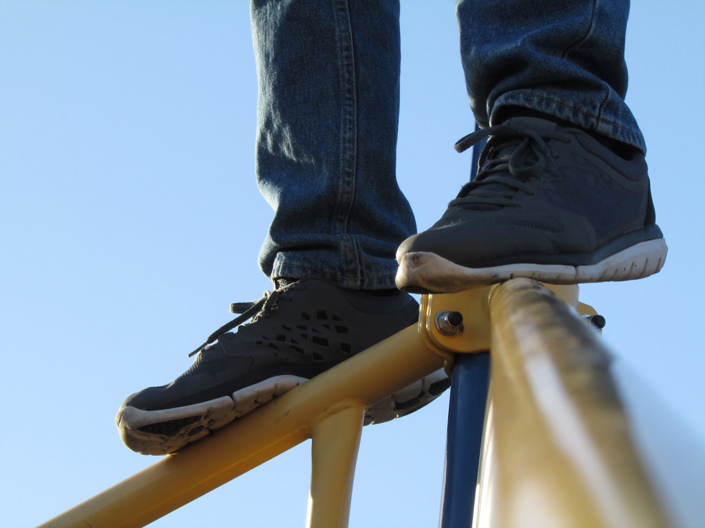 Feet on top of metal playground equipment 