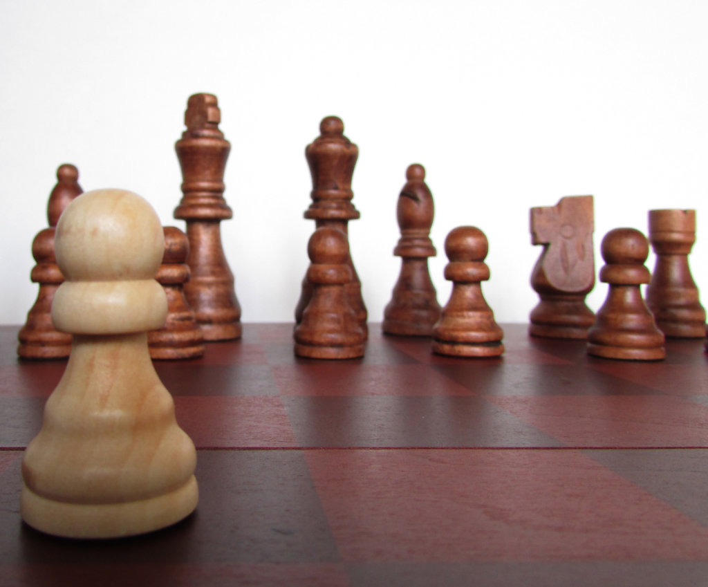 White wooden chess pawn advancing a space