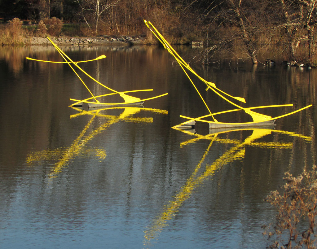 Bright yellow metal sculptures rising from the water 